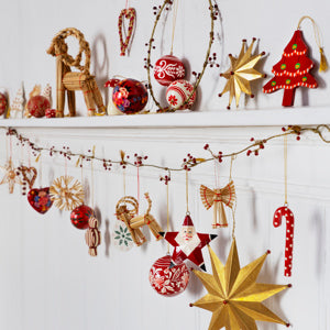 Hand-Painted Santa Star by Madam Stoltz, featured on a festive Christmas mantel with straw ornaments and berry garland.
