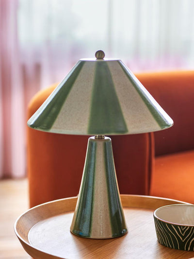 Bloomingville Olive Table Lamp with green and white striped conical shade and base on a wooden table. Modern home decor.