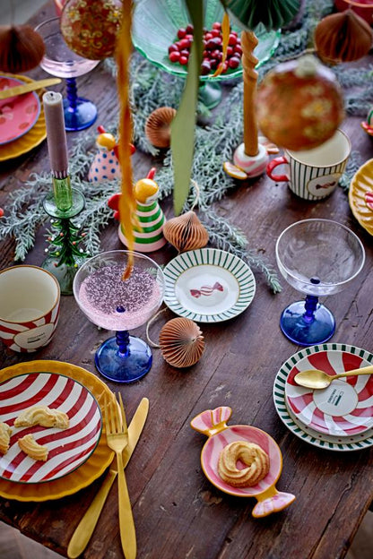 Festive Christmas table with Caramella Serving Plate, Multi | Bloomingville, colorful dishes, candles, and greenery.