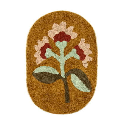 Oval Tufted Bath Mat by Madam Stoltz with a floral design, featuring light pink and red flowers with green leaves on a mustard background.