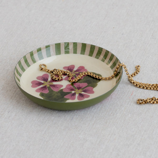 Roomytown Round Enamel Tray featuring green stripes and a delicate pink floral design, holding a golden chain.