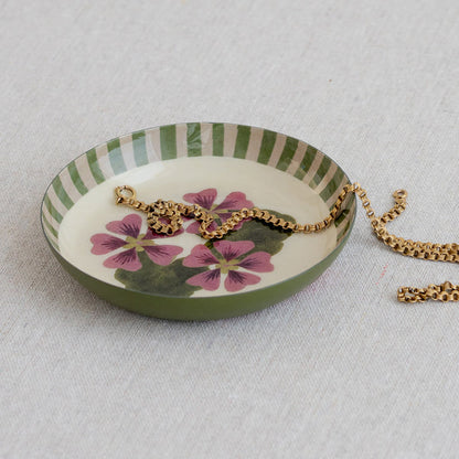 Roomytown Round Enamel Tray featuring green stripes and a delicate pink floral design, holding a golden chain.