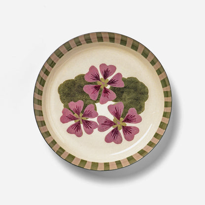 Roomytown Round Enamel Tray featuring a purple floral design with green leaves and a striped rim on a creamy background